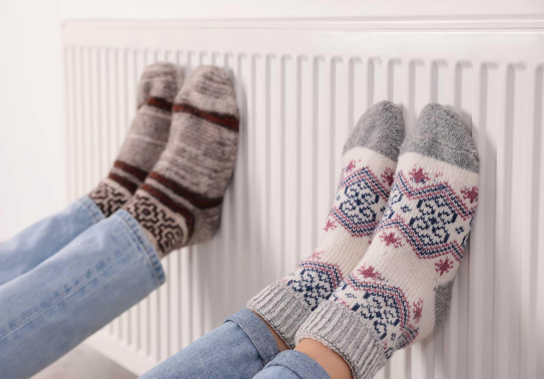 A pair woolly socked feet enjoying the heat of a radiator