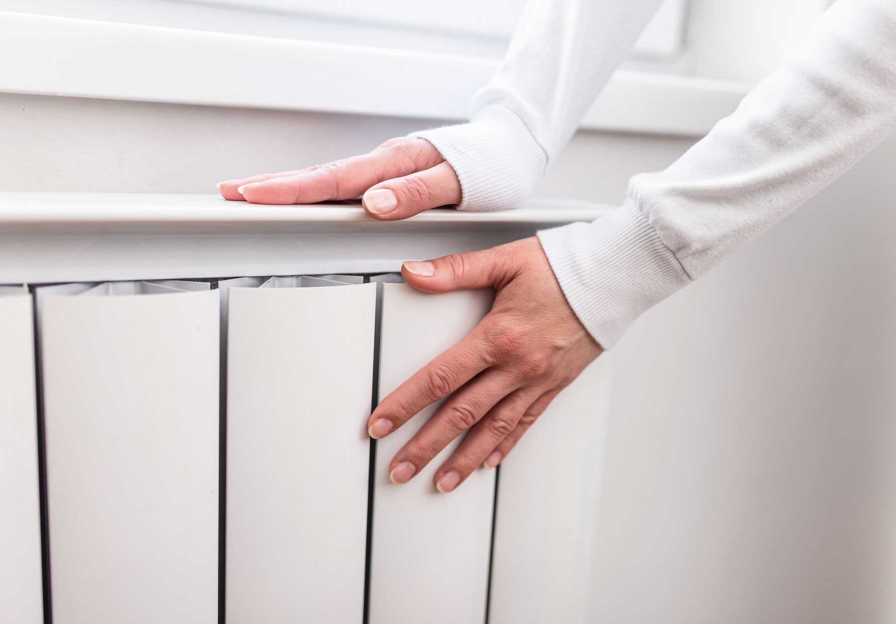 Hands warming on a radiator